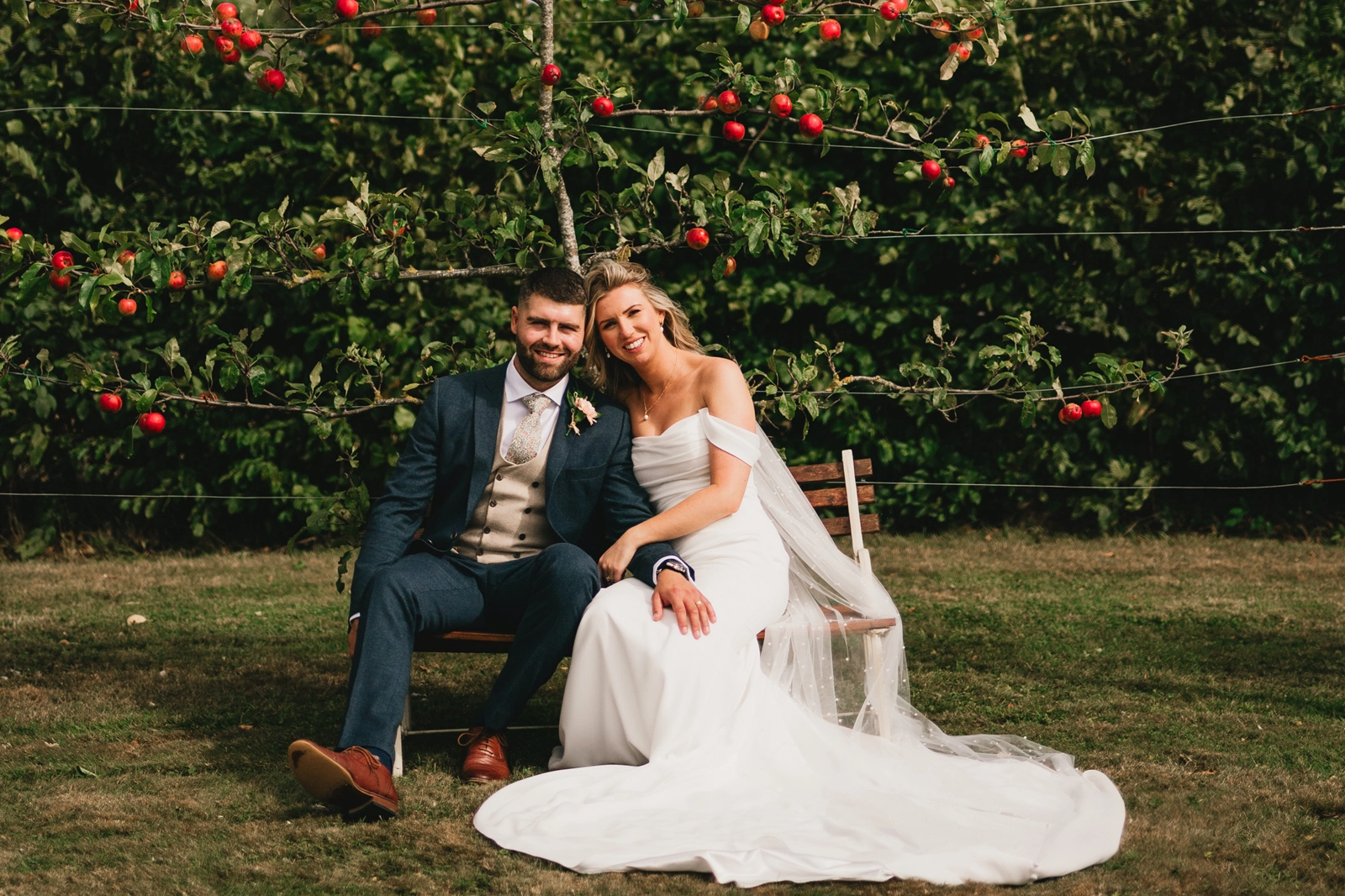 Bride and groom infront of the espalier apple trees