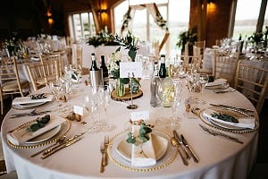 Round tables, gold chargers and greenery