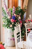 Floral milk churns behind top table