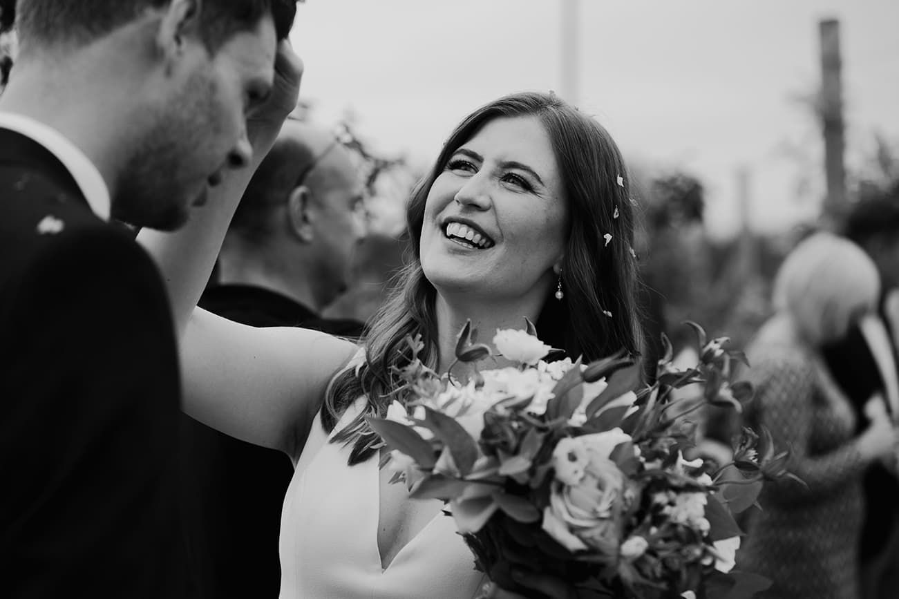 Bride picking confetti out of grooms hair